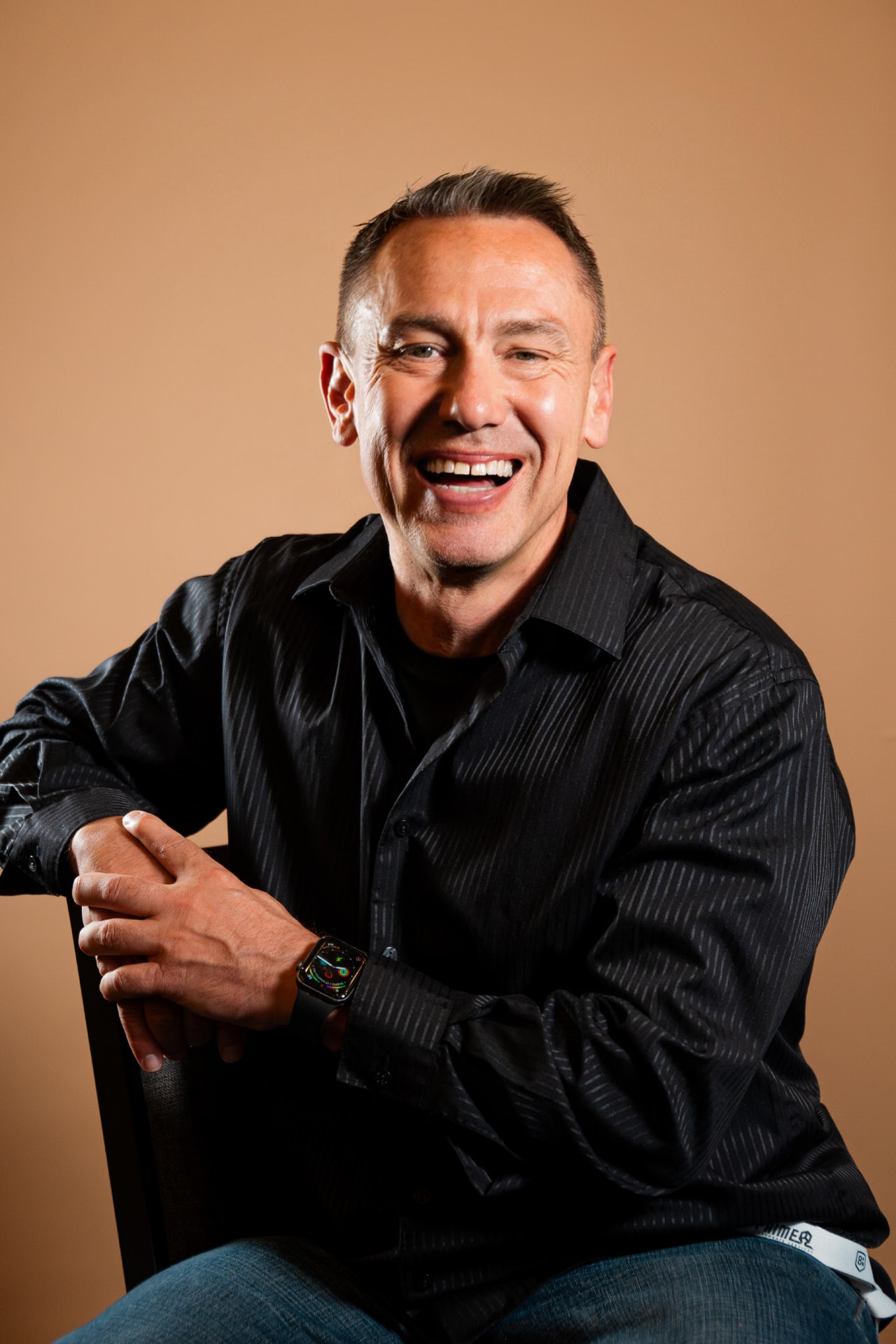 Doc Tom Having, Spiritual Fitness teacher, seated and smiling